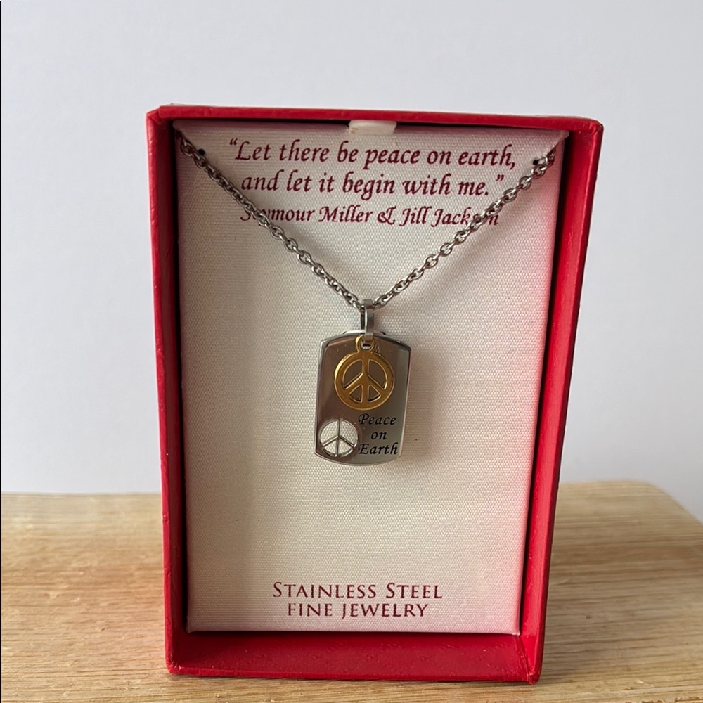 Stainless steel peace necklace. New in box.